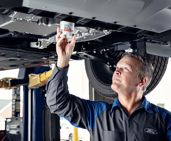 Ford mechanic working udner car