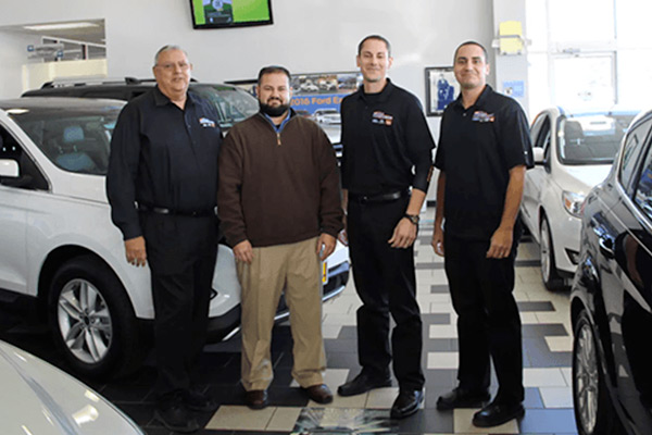 Car keys sitting on a pile of paperwork with a credit card and caluculator blurred out in the background