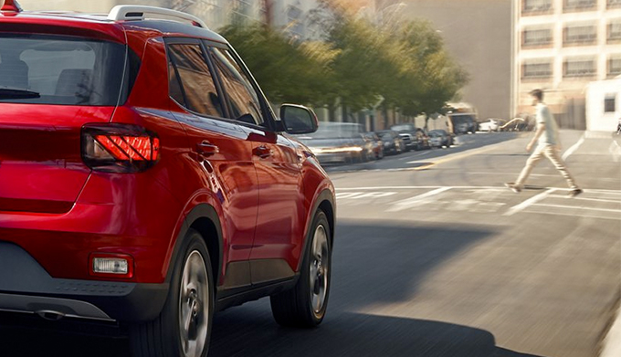rear view of a 2022 Hyundai Venue driving down the city street