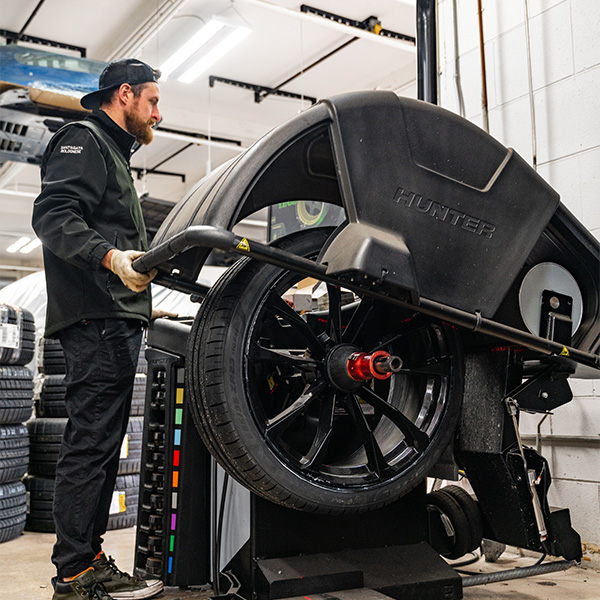 Man using a tool to adjust a tire