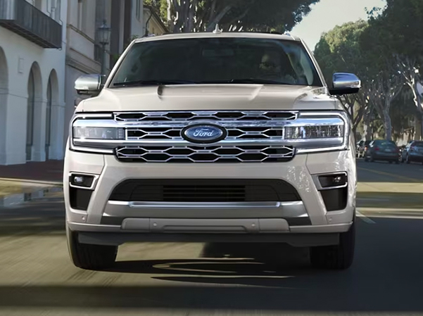 Front view of a white 2023 Ford Expedition driving through the city