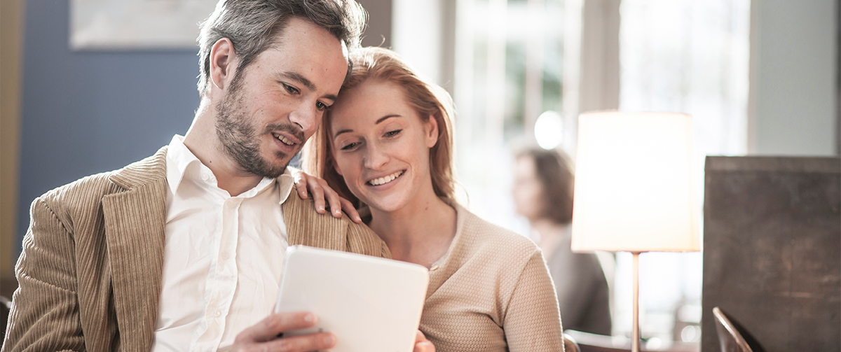 Happy couple looking at an ipad