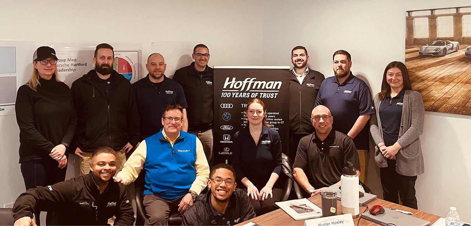 Group of people standing beside a Hoffman sign