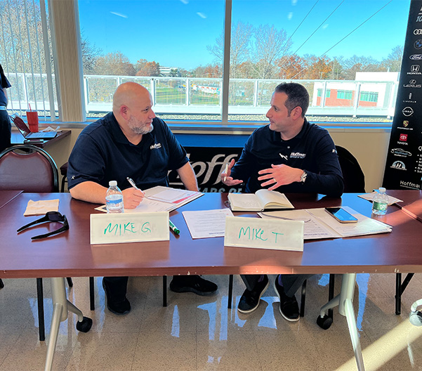Two Hoffman leaders talking through strategy ideas while sitting at a presentation table