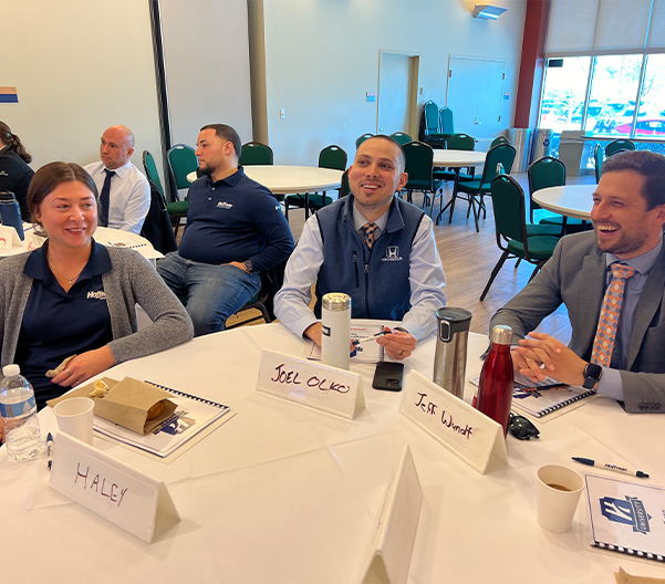 Hoffman Leaders sitting around a table at a conference