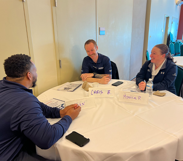 Hoffman Leaders sitting around a table engaging in conversation