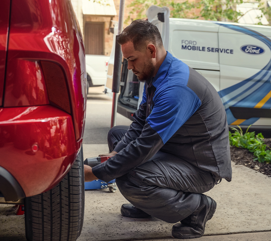 A Ford Mobile Service Technician works on a Ford vehicle.