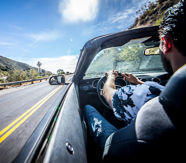 Man driving down the highway on a summer day