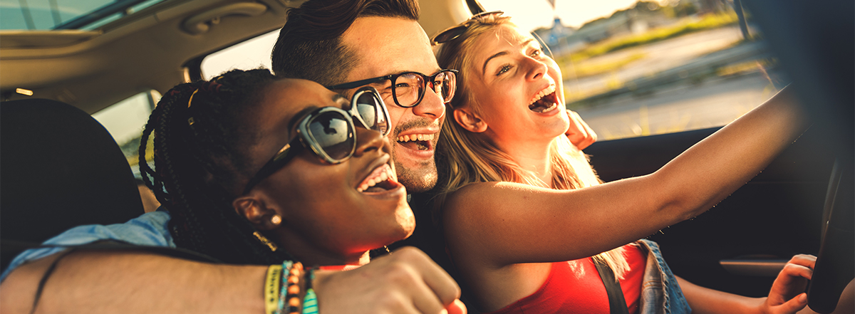 Three happy friends riding in a car