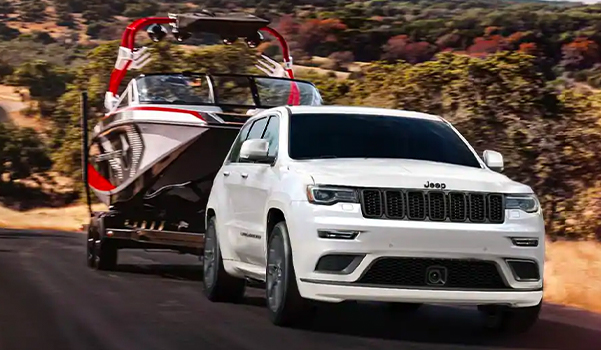 The 2021 Jeep Grand Cherokee towing a boat.